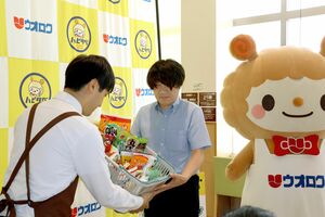 ウオロク中条店での贈呈式で、食品を受け取るフードバンクたいないの中村淳代表(右)=6月29日、胎内市野中