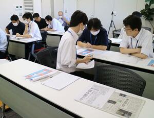 新聞を教材に文章のまとめ方を学ぶシアンスの社員たち=24日、新潟市中央区