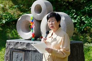 慰霊碑の前であいさつする日弁連の渕上玲子会長=7日午前、長野県大町市