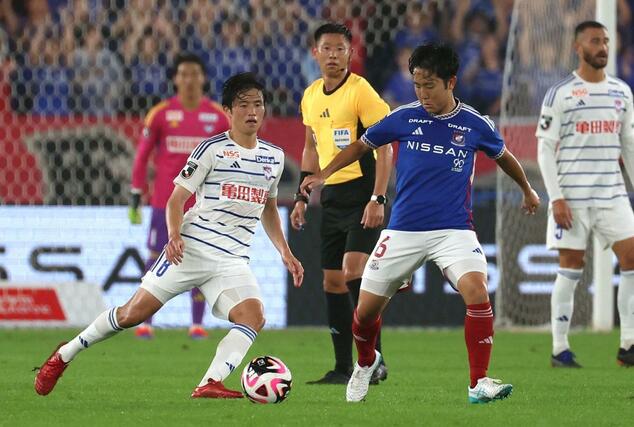 後半、ＭＦ宮本英治がぴったりマークする＝日産スタジアム