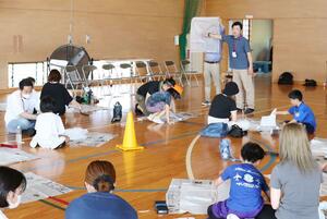 田尻小学校の3年生と保護者に、災害時に役立つ道具の作り方を教える防災学習サポーター=柏崎市安田