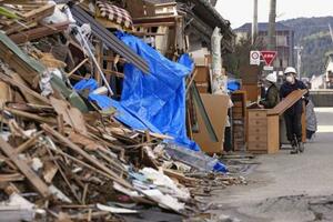 能登半島地震で被災した家屋から家財道具を運び出すボランティア=2024年2月、石川県輪島市