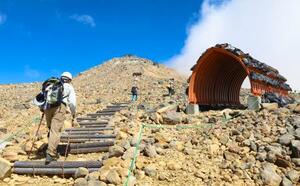 御嶽山の長野県側を登る火山防災訓練の関係者=26日午前