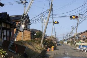地震による液状化被害で建物や電柱が傾いた石川県内灘町の西荒屋地区=3月22日午後