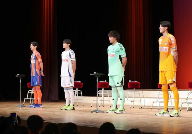 激励会で、ユニホームを披露する選手。左からDF稲村隼翔、MF笠井佳祐、GK田代琉我、GK内山翔太=新潟市中央区