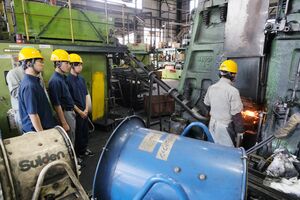 「新発田鍛工」で鍛造の作業を見学する足立学園高の生徒＝新発田市佐々木