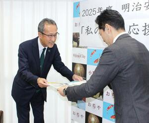 「私の地元応援募金」の目録を手渡す明治安田生命保険の赤木正道長岡支社長(左)=小千谷市役所