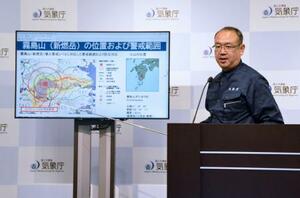記者会見する気象庁火山監視課の平祐太郎課長=23日夜、気象庁