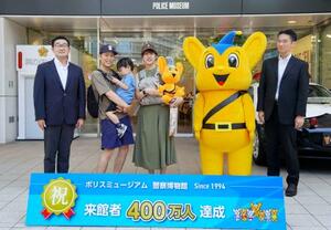 警察博物館「ポリスミュージアム」の400万人目の来館者となり、記念撮影する川上謙太さん(左から2人目)ら家族。璃空ちゃんはご機嫌ななめ=17日午前、東京都中央区