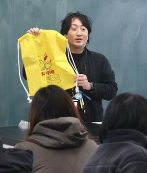 入学説明会で体育着袋の寄贈について説明する阿賀野市社会福祉協議会の職員=阿賀野市の堀越小学校