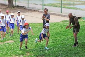 前川小の児童に走り方を教える松永紘明さんとゲディミナス・グリニウスさん＝１５日、長岡市前島町