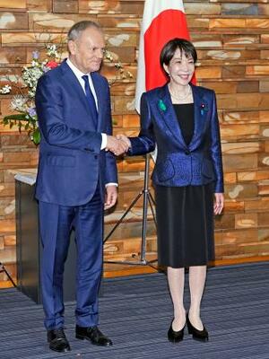 首脳会談を前に握手を交わすポーランドのトゥスク首相(左)と高市首相=15日午前、首相官邸