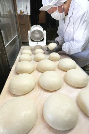 手作業で丁寧に丸められる鏡餅=28日、新潟市中央区の笹川餅屋