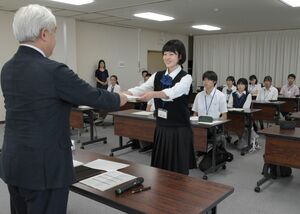 1年間の講座を終え、上野正人副学長から修了認定証を受け取る高校生=上越市山屋敷町