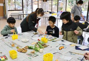 郵便局員に教えてもらいながら絵手紙を描く児童=阿賀町津川