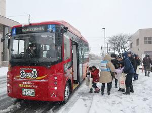 本格運行を前に電気自動車のバスに試乗する市民ら=3月3日、村上市三之町