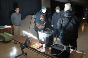 停電を想定し、暖房や照明を切った中で避難所生活を体験する市民ら=新潟市西区寺尾上3