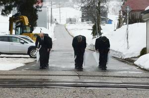 死亡事故が起きた踏切に向かって頭を下げるJR東日本の深沢祐二社長(中央)ら=2月1日、津南町上郷寺石