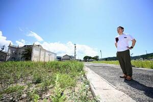 実家の跡地(左)を訪れた清水宏紀さん=9日、石川県輪島市