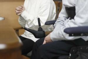 3月、私立高校入試を巡り取材に応じる車いすの生徒(手前)と保護者=香川県内