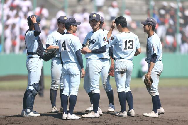新潟明訓-開志学園 7回、マウンドに集まる新潟明訓の選手たち=新発田市五十公野
