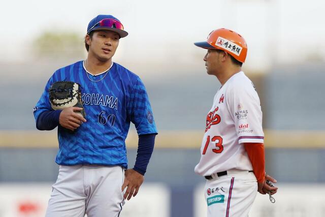 １回オイシックス無死一塁、言葉を交わすＤｅＮＡの一塁手知野直人（左・新潟アルビレックスＢＣ出身）とオイシックスの稲葉大樹コーチ＝６月１８日、エコスタ