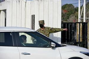 　家宅捜索のため陸上自衛隊えびの駐屯地に入る捜査車両＝２９日午前、宮崎県えびの市