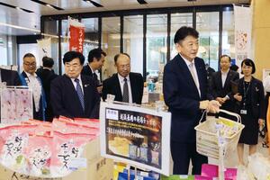 東京商工会議所主催の県産品物産展を訪れた東京電力の小早川智明社長(手前右)ら=15日、東京・丸の内