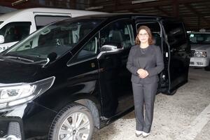 やまとタクシーが観光タクシーとして運行している車両と、専属ドライバーの二階堂パサナさん=南魚沼市浦佐