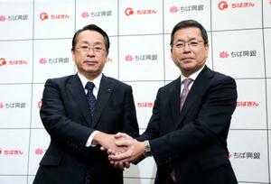 記者会見を終え握手する千葉銀行の米本努頭取(左)と千葉興業銀行の梅田仁司頭取=29日午後、千葉市