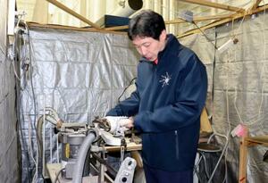 　専用の作業スペースで研磨について説明する日下匡力コーチ＝１月、埼玉県内