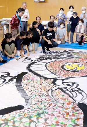 竜の絵に目を描き入れる諏訪小の児童=7月30日、上越市上真砂