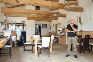 エディブルフラワーのスイーツを味わえる「ハナカフェ・ソエル」の店内を見て回る脇坂裕一さん(右)=阿賀野市境新