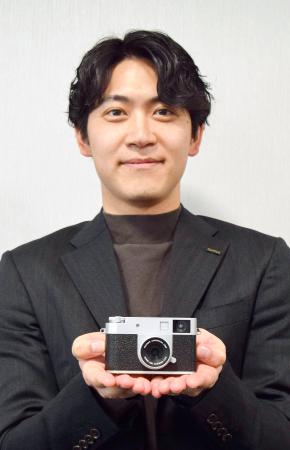 　コンパクトデジタルカメラ「Ｘ　ｈａｌｆ」を手に持つ富士フイルムの米山諒さん＝さいたま市