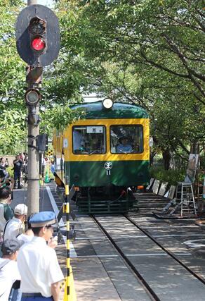家族連れらを乗せて走る旧新潟交通電車線の「かぼちゃ電車」＝２８日、新潟市南区