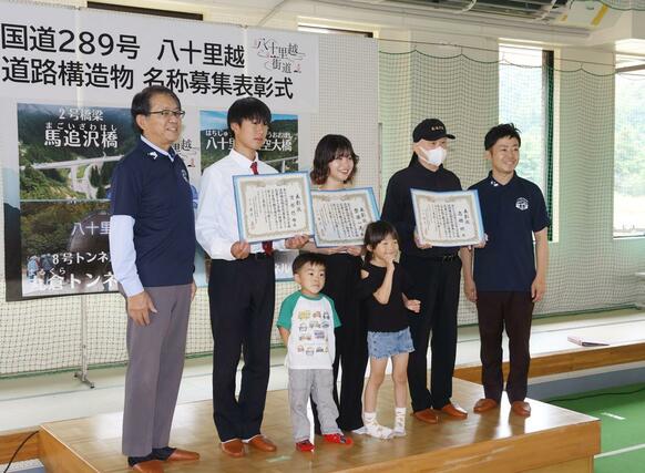 「八十里越天空大橋」の名称が採用され、表彰された三条市の齋藤一美さん（左から３人目）ら＝２７日、三条市南五百川