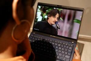 昨年12月のノーベル平和賞授賞式で歌うダニー・オーシャンさんの動画を見るジェニフェルさん=1月22日、コロンビア・ククタ(共同)