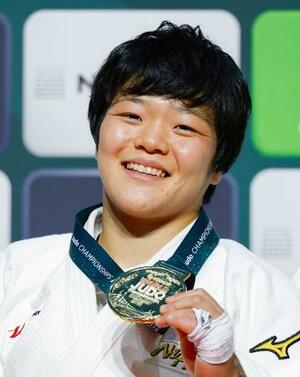 柔道の世界選手権女子63キロ級で初出場優勝を果たし、金メダルを手に笑顔を見せる嘉重春樺=16日、ブダペスト(共同)