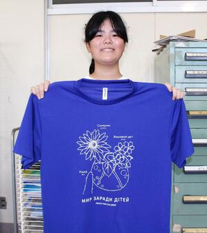 デザインしたTシャツを掲げる中野莉緒さん=小千谷市東栄3