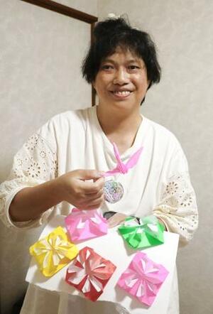自ら折った折り紙を手にする奥津ゆかりさん。神奈川県内の別のグループホームで新たな生活を送っている=16日