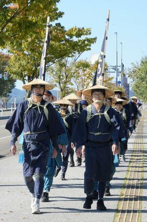 江戸時代の人足の装束をまとい、佐渡島で採掘された金銀が運ばれた道をたどった「御金荷の道」ウオークin上越・高田=11月4日、上越市