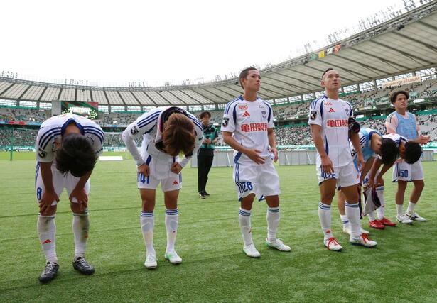 試合に敗れ、サポーターに向かって頭を下げる新潟の選手=18日、味の素スタジアム