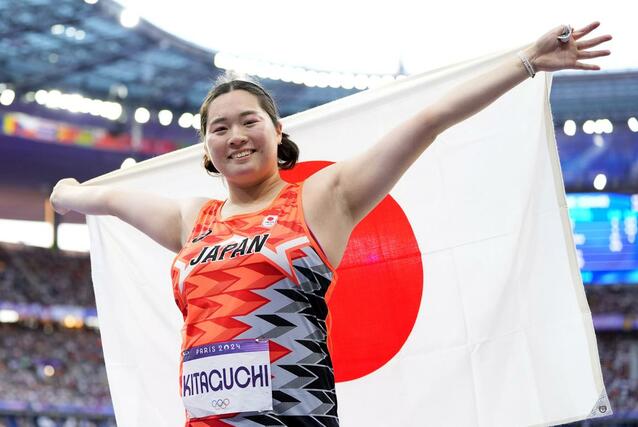 パリ五輪の陸上女子やり投げで金メダルを獲得し、日の丸を掲げる北口榛花＝１０日、パリ郊外（共同）