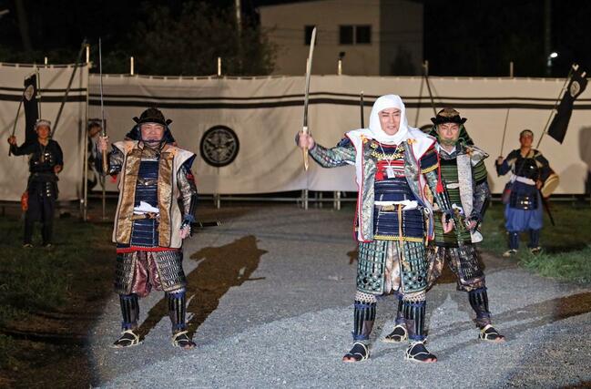 太刀を高々と掲げて勝ちどきを上げる上杉謙信役の松平健さん＝２３日、上越市の春日山城史跡広場