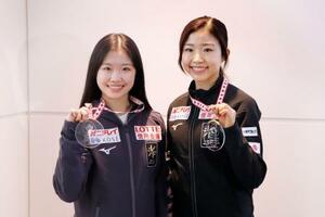 GP第3戦スケートカナダから帰国し、メダルを手に撮影に応じる千葉百音(右)と中井亜美=3日、羽田空港
