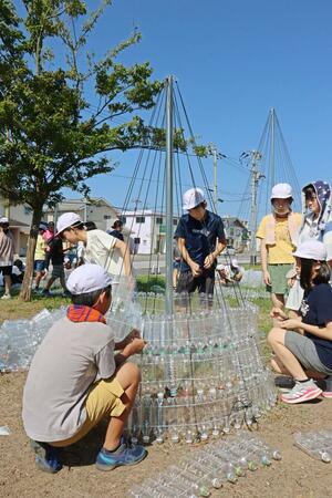 ペットボトルを骨組みに取り付け、エコツリーを作る葛塚東小の児童ら=新潟市北区東栄町1