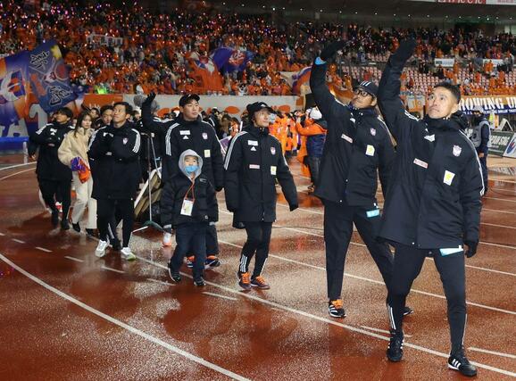 新潟－Ｃ大阪　シーズンを終え、サポーターへ手を振る松橋力蔵監督（右）＝ビックスワン