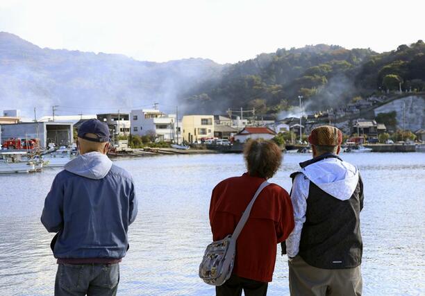 
大分市佐賀関の大規模火災現場を見つめる人たち＝１８日、午後９時半ごろ
