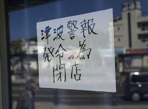 岩手県に津波警報が発令され、宮古駅前の売店に張られた臨時休業を知らせる張り紙=30日午後2時2分、岩手県宮古市