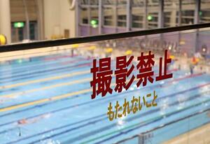 スポーツ施設にあるプールの観客席前に掲示された「撮影禁止」の文字=22日、三重県鈴鹿市